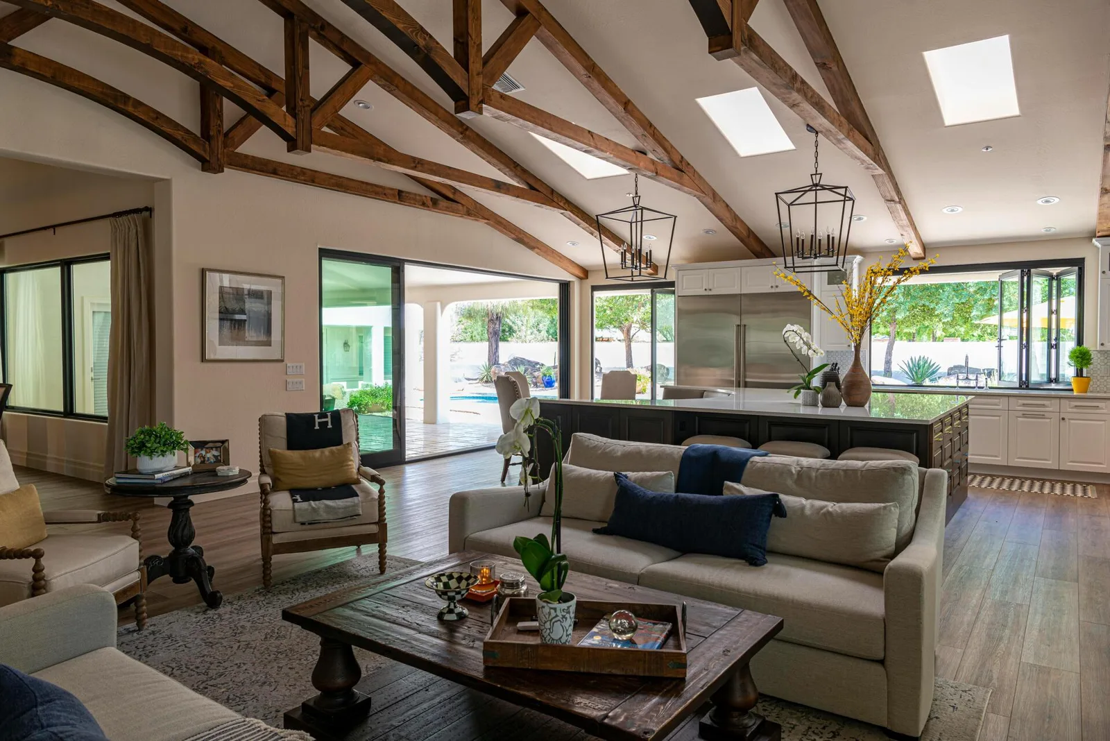 A light, open-plan living space with warm wooden beams and a contemporary kitchen